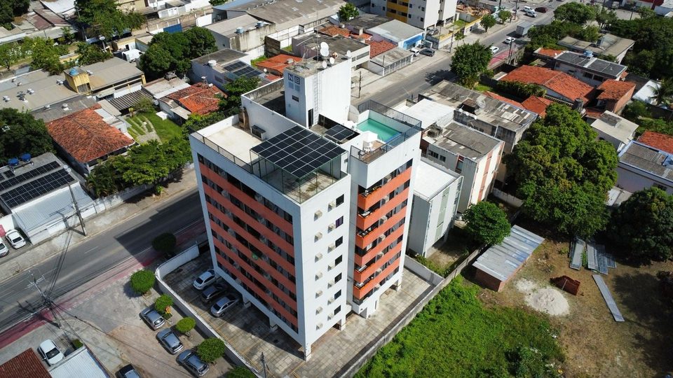Edifício de fachada laranja no Recife com usina solar instalada na cobertura