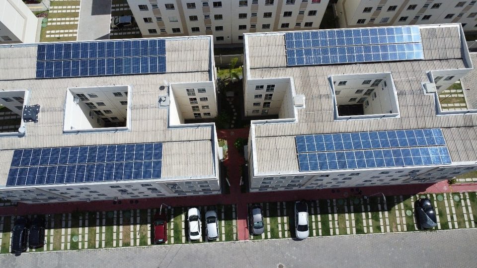 Vista aérea de cobertura corporativa com longas fileiras de painéis solares